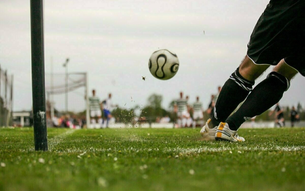 Eine Ecke wird auf einem Fußballfeld in den Strafraum geschlagen Eine Ecke wird auf einem Fußballfeld in den Strafraum geschlagen